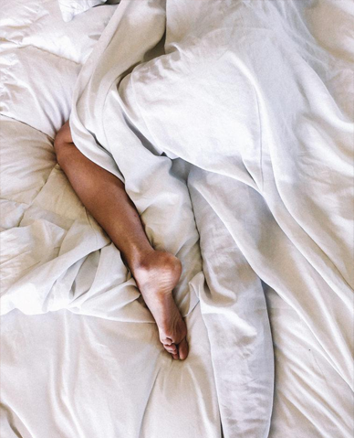 A woman stirring in bed at the discomfort caused by restless legs syndrome.