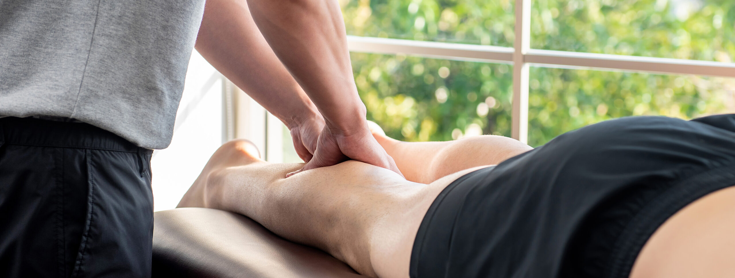 Treating severe muscle cramps, a man receives massage therapy on his calf.