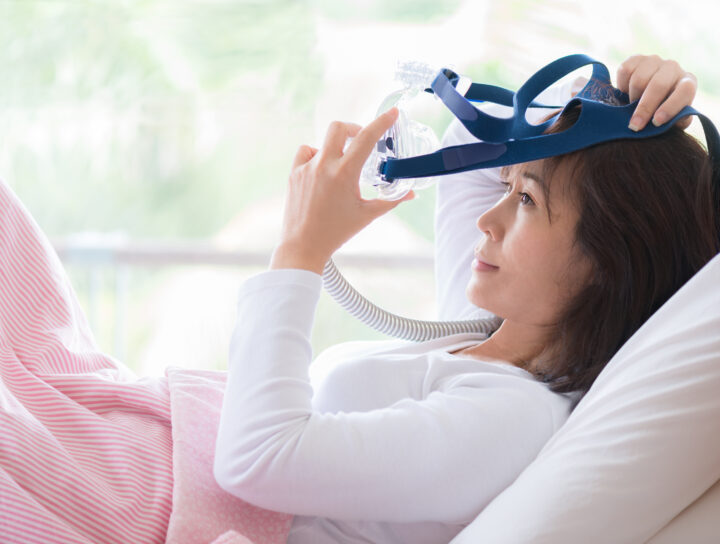 A woman getting ready for bed with the best CPAP therapy mask her doctor recommended to her.