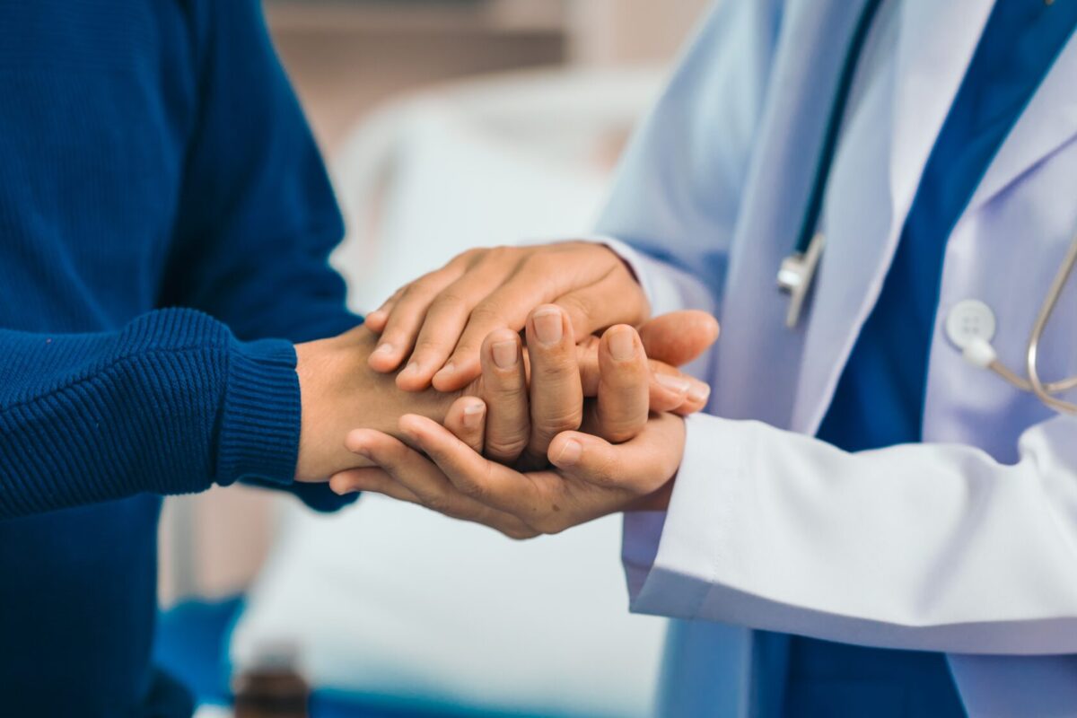 A close-up of a doctor holding their patient's hands, discussion their comprehensive men's and women's health services in NJ.