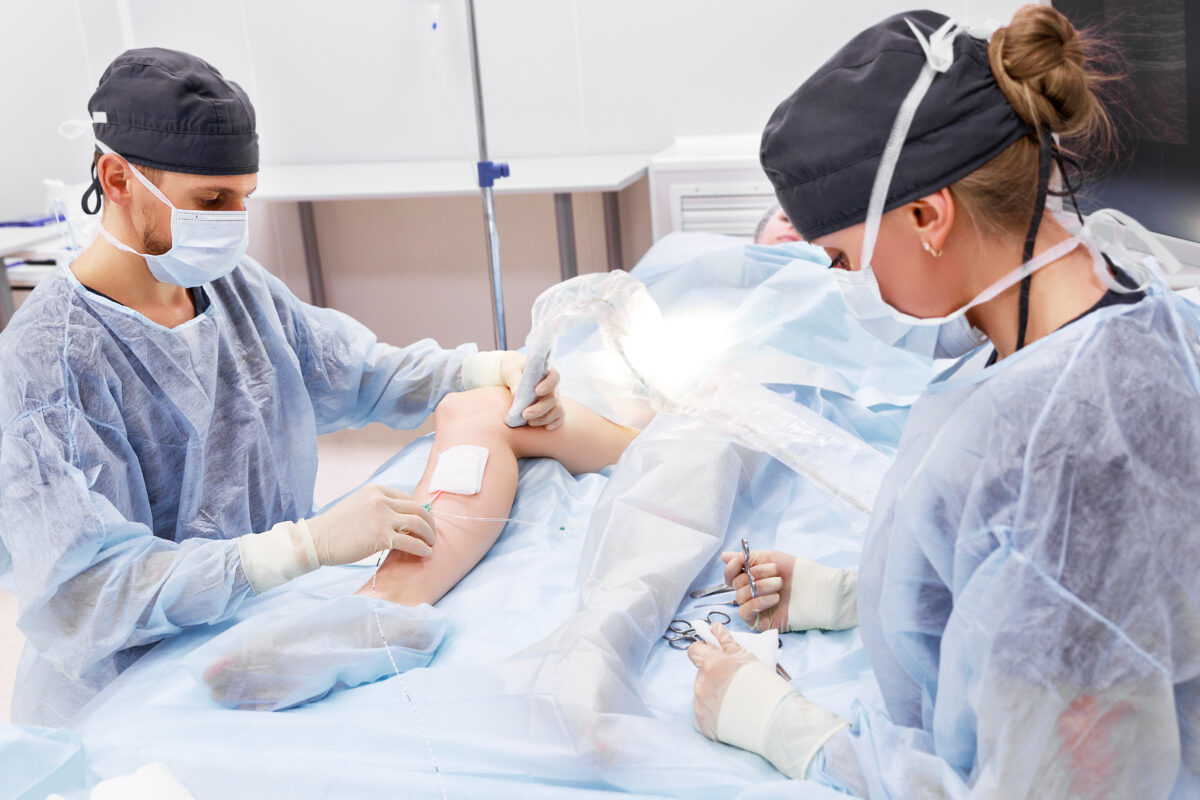 A pain management specialist doctor performs deep vein ablation treatment on a patient during minimally invasive surgery.