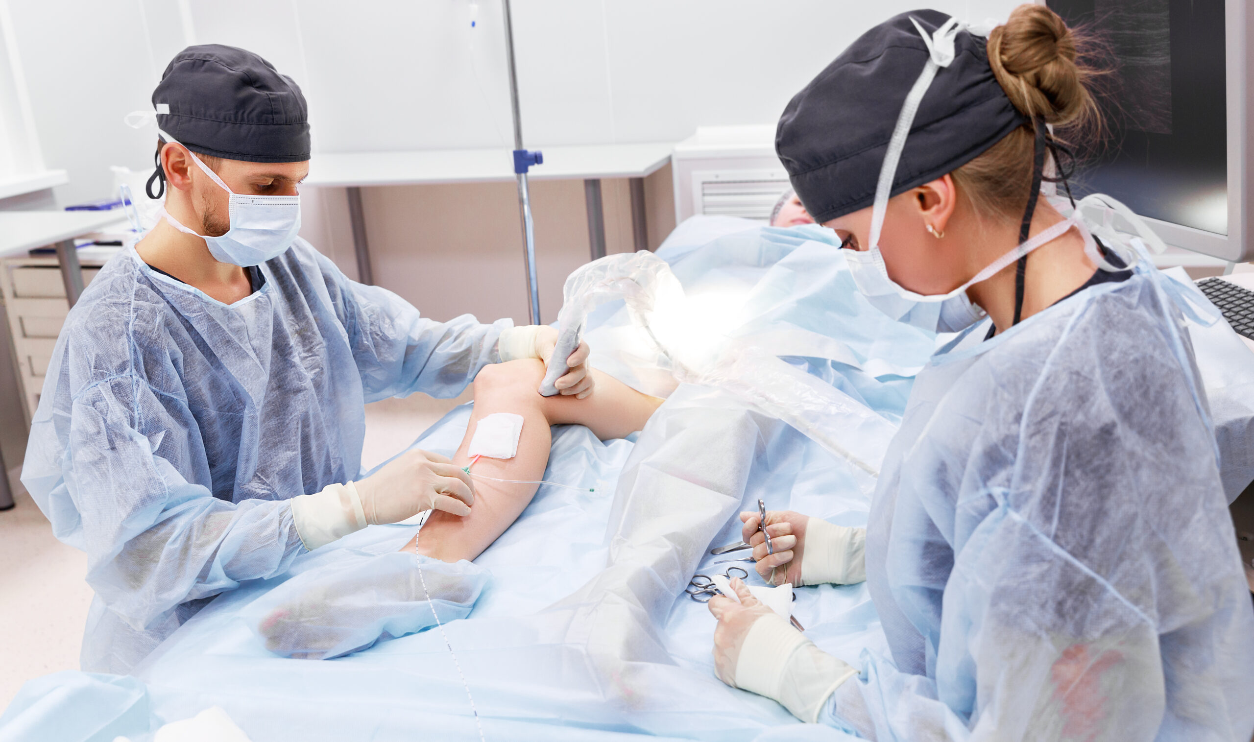 A pain management specialist doctor performs deep vein ablation treatment on a patient during minimally invasive surgery.