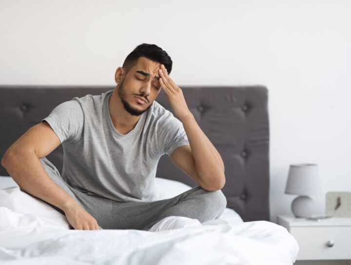A man waking up without much sleep, thinking about sleep apnea mask alternatives.