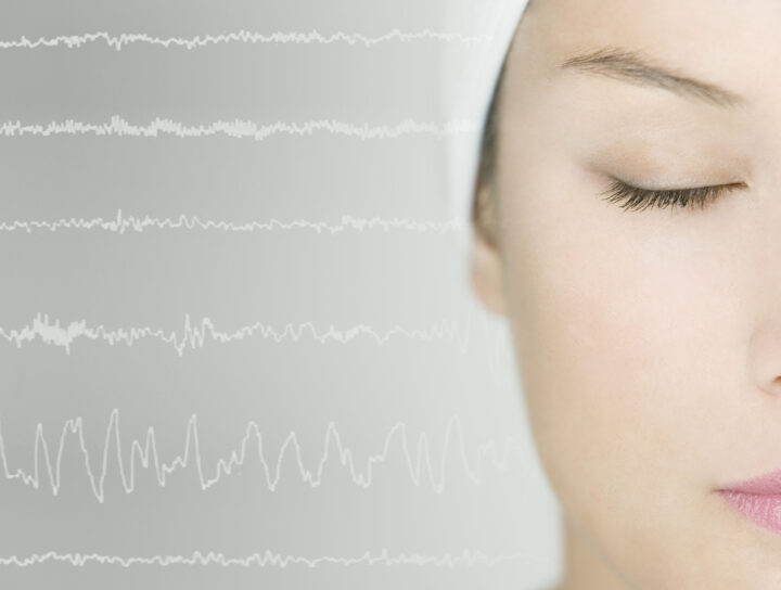 An at home sleep study is illustrated by a woman with her eyes closed, as a graphical chart analysis line is next to her head.