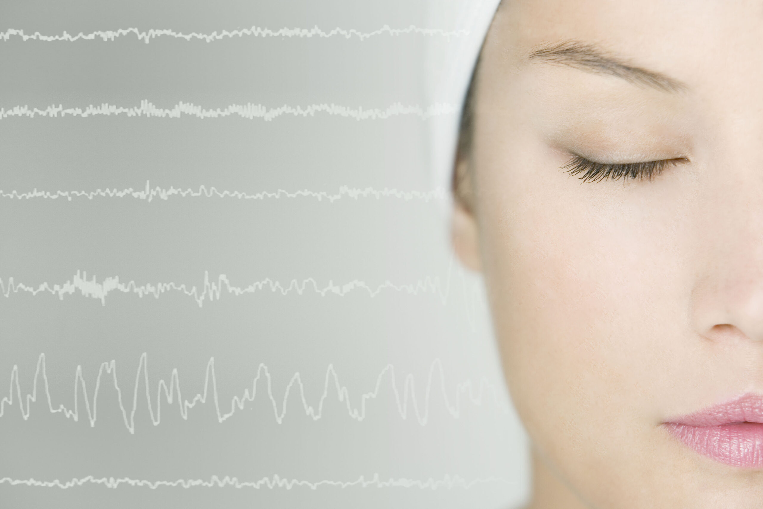 An at home sleep study is illustrated by a woman with her eyes closed, as a graphical chart analysis line is next to her head.