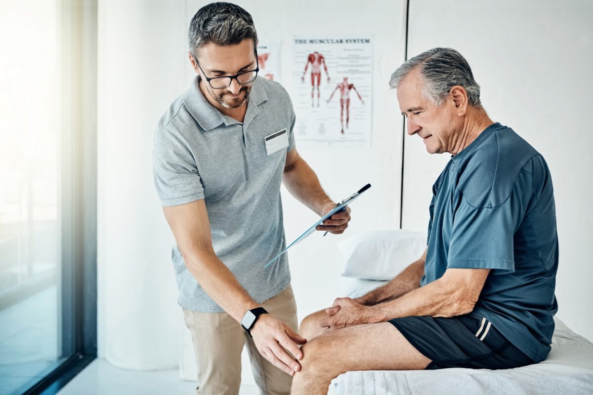 An older man seeking out knee pain treatment with a pain management specialist during a visit.