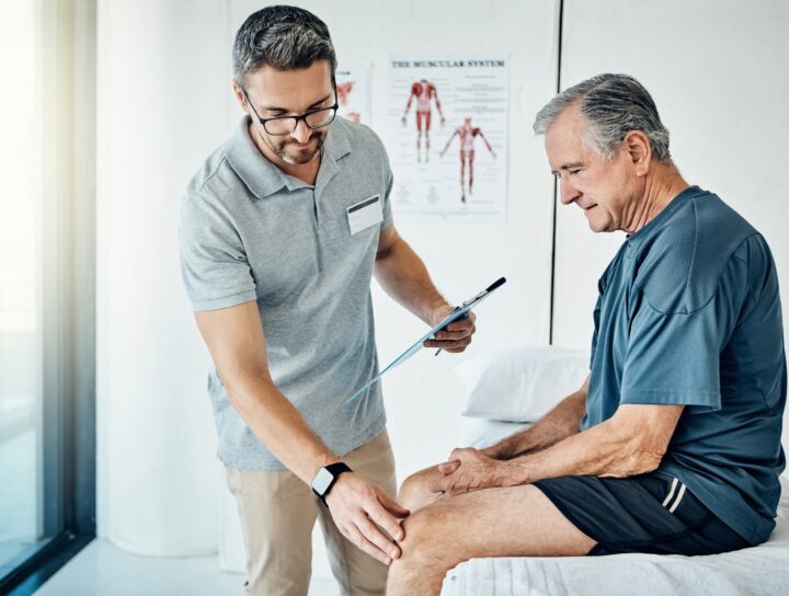 An older man seeking out knee pain treatment with a pain management specialist during a visit.