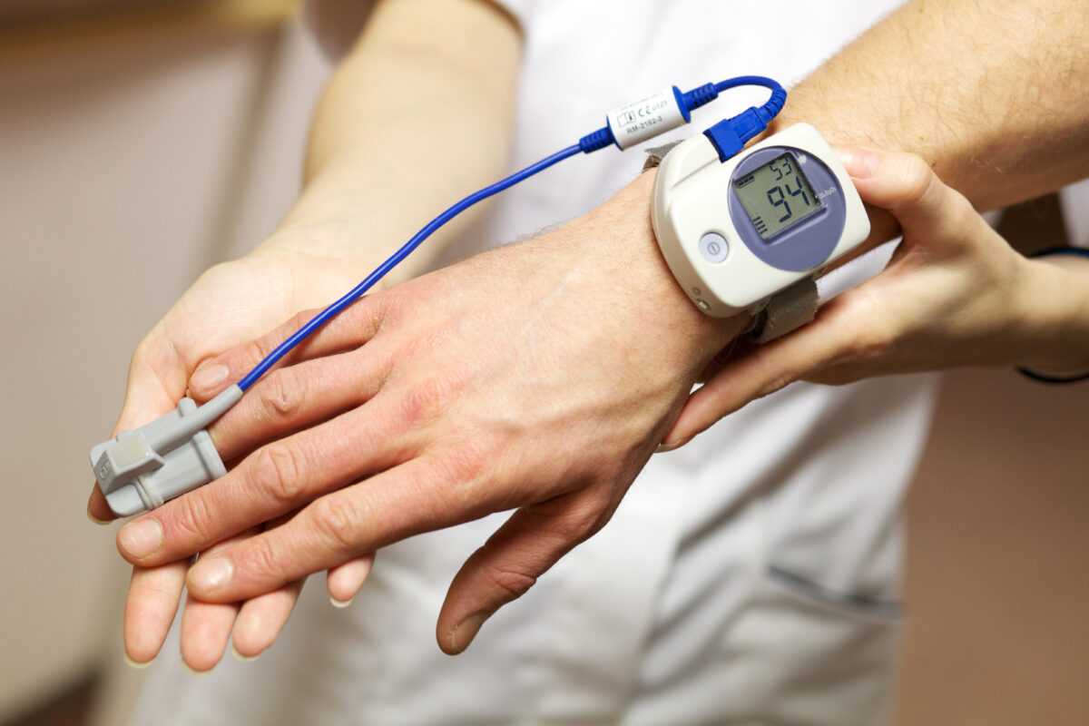 Personal stories behind sleep study at home tests reveal today's technological conveniences, as shown by this oxygen meter on an apnea patient's wrist and finger.