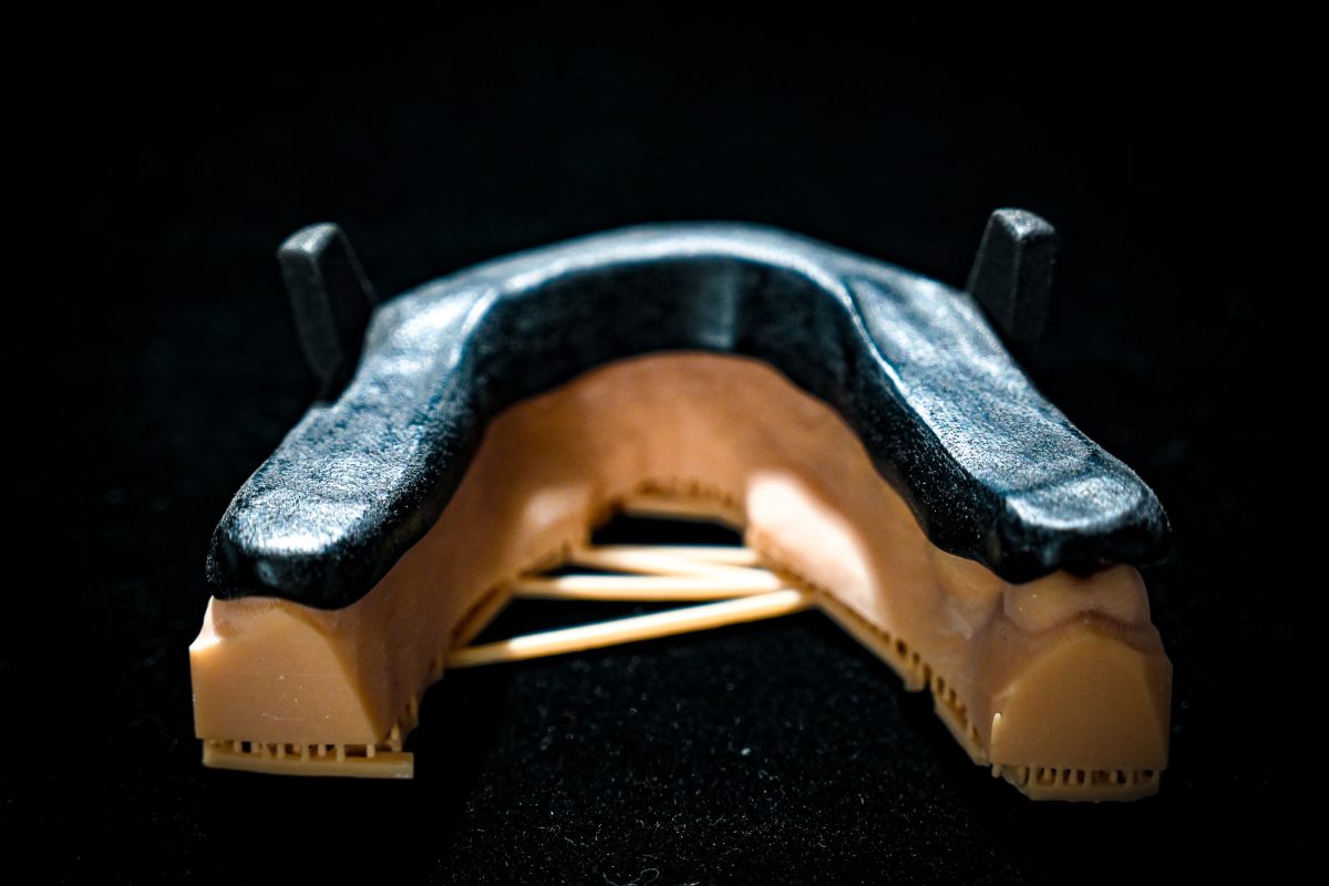A brand new MAD sleep apnea device, or Mandibular Advancement Device, is casted in a spotlight with a black background.