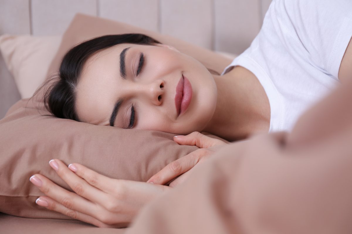 A woman who found the right sleep apnea treatment is shown getting a restful, complete night's sleep.