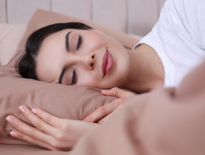 A woman who found the right sleep apnea treatment is shown getting a restful, complete night's sleep.