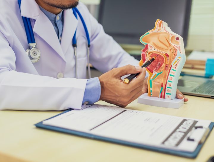 A doctor explaining OSA treatment with a diagram tool on his desk with a pen and clipboard.